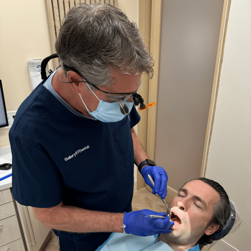 Dentist performing a dental checkup on a patient in a clinic while discussing proper Invisalign after care and oral hygiene – invisalign after care