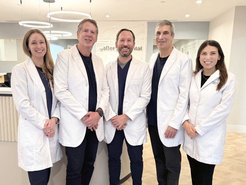 Friendly and experienced dental professionals standing together inside a modern New York City dental office, showcasing a welcoming team dedicated to comprehensive and patient-focused dental care – dentist nyc